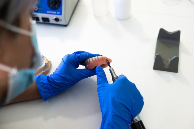 Closeup shot of hands of a dental technician making new Prosthetics dental in laboratory. Capitol Dental Laboratory